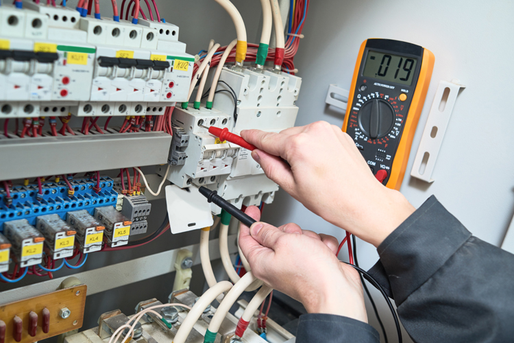Electrician testing a switchboard for a rental property compliance check in Townsville